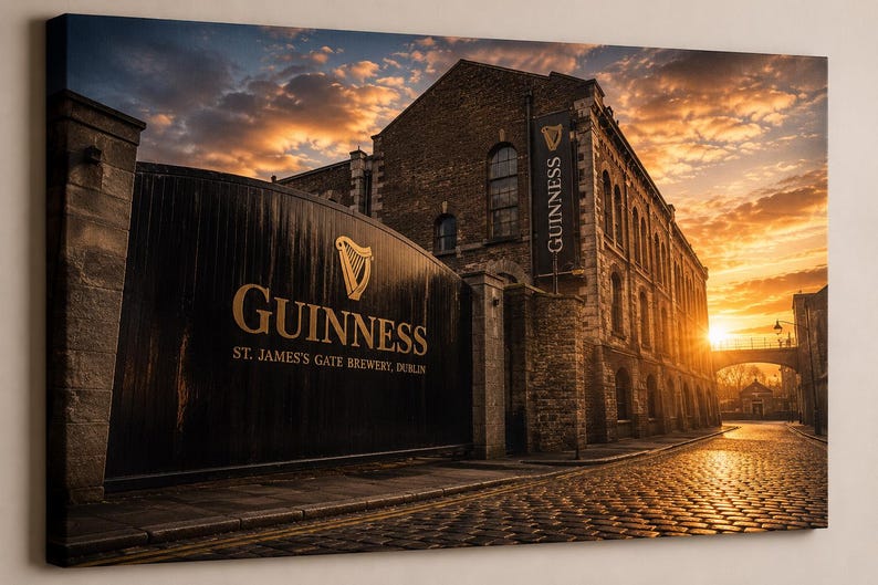 May include: A canvas print of the Guinness brewery in Dublin, Ireland, at sunset. The image features the brewery's entrance gate with the Guinness logo and the text "St. James's Gate Brewery, Dublin." The sky is filled with orange and yellow hues.