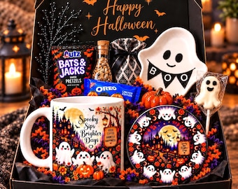 Op de afbeelding: Een zwarte geschenkdoos met een witte mok met een print van spoken en een spookhuis, een bijpassend bord, een spookvormig keramieken schaaltje met de tekst BOO, een spooklolly, een zak Utz-pretzels, een pakje Oreo en een klein glazen potje.