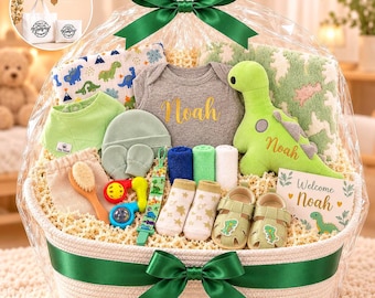 Op de afbeelding: Een babycadeaumand verpakt in doorzichtig plastic met een groen lint, met een grijze romper met de naam Noah, een groene pluche dinosaurus, een deken met patroon, een groen slabbetje, een mutsje, wantjes, sokjes, babyschoentjes, een borstel en een rammelaar.
