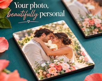 May include: Two square photo plaques featuring a romantic wedding portrait of a couple embracing amidst flowers. The text "Your photo, beautifully personal" is printed in white and pink script above the plaques on a dark teal background.