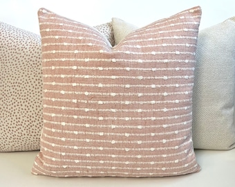 May include: Three decorative throw pillows with different patterns. The center pillow is pink with white stripes and dots. The pillow on the left is white with pink polka dots. The pillow on the right is white with a gray herringbone pattern.