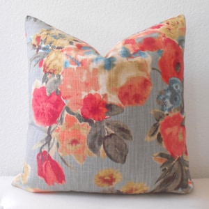 Funda de almohada decorativa floral con acuarela multicolor en gris, rojo y azul.