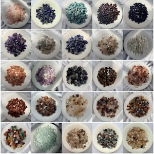 May include: A collection of twenty-five white ceramic plates, each filled with a distinct variety of small, polished tumbled gemstones in various colours including pink, blue, green, purple, brown, black, clear, and multi-coloured stone mixes.