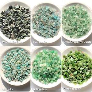May include: Six white bowls containing small tumbled gemstones: dark green and black Peacock Eye Stone, light blue Clear Apatite, pale green Green Strawberry Quartz, light teal Amazonite, bright green Jinling Jade, and deep green Green Jadeite.