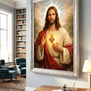 Peut inclure: Un portrait religieux encadr&eacute; repr&eacute;sente un homme aux longs cheveux bruns, une barbe et un halo. Il porte une robe blanche et un manteau rouge, avec un c&oelig;ur brillant sur sa poitrine. Le cadre argent&eacute; orn&eacute; est accroch&eacute; &agrave; un mur bleu clair.