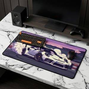 May include: A rectangular mouse pad featuring a white sports car with a pixelated design, emitting smoke. The pad has a black border and a purple and orange sky background. A black keyboard and mouse are on the pad.