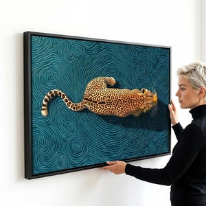 May include: A rectangular framed wall art piece featuring a leopard with a spotted coat positioned centrally against a deep teal background filled with intricate, swirling, wave-like patterns that create a sense of movement and depth.