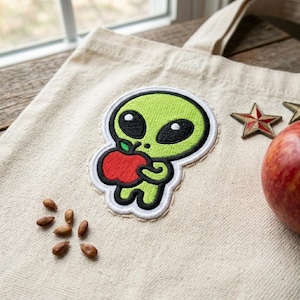 Cute Green Alien Holding Apple Embroidered Patch - Kawaii Space Iron On Badge for Denim Jackets, Backpacks and Hats - DIY Gift Ideas