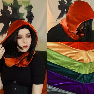 May include: A hooded scarf in a variety of colors, including orange, gold, green, dark green, purple, and gray. The scarf is made of velvet and can be worn as a hood or a scarf.