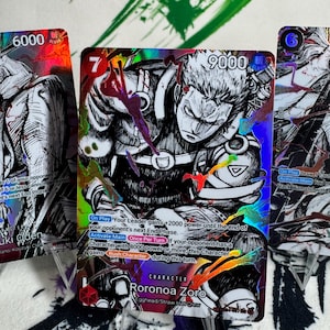May include: A holographic One Piece trading card featuring Roronoa Zoro with a power level of 9000 and a cost of 7. The card displays black and white ink-style artwork of the character with red accents, game text, and a shiny, reflective finish.