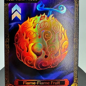 May include: A rectangular trading card featuring a holographic Flame-Flame Fruit illustration in shades of orange, red, and yellow. The card has a dark blue background, a gold ornate border, and text that reads Your Turn +1000 and Flame-Flame Fruit.