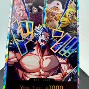 May include: A rectangular trading card with a holographic finish featuring a central muscular character with blue and white hair, surrounded by four smaller character portraits at the top. The card includes the text DON!! CARD and Your Turn +1000.