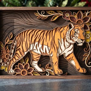 May include: A multi-layered wooden wall art piece featuring a tiger walking through stylized floral elements. The design uses various shades of brown, tan, and orange wood tones to create depth, all enclosed within a rectangular dark wood frame.