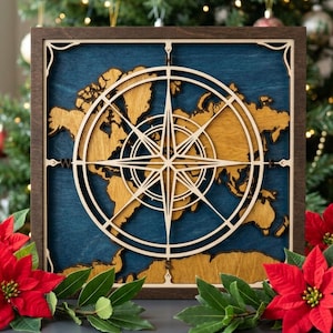 May include: A square wooden wall art piece featuring a layered world map in natural wood tones against a deep blue background. A large, intricate laser-cut compass rose is centered over the map, with the letters N, S, E, and W marking the cardinal directions.