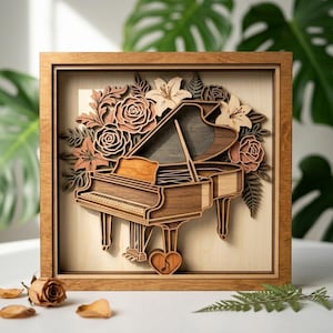 May include: A wooden framed artwork featuring a detailed, layered design of a grand piano. The piano is surrounded by laser-cut flowers in shades of brown and beige. A heart shape is below the piano. The artwork is set against a light background.