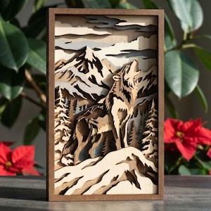 May include: A layered wooden art piece depicting a wolf howling in a mountain landscape. The artwork features a wolf, trees, and snow-capped mountains in shades of brown, gray, and white, framed in a dark wood. The piece is approximately 12 inches tall.