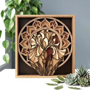 May include: A square wooden wall art piece featuring a multi-layered laser-cut design of an iris flower centered within a circular mandala pattern. The artwork uses various shades of natural wood, ranging from light tan to dark brown, creating depth.