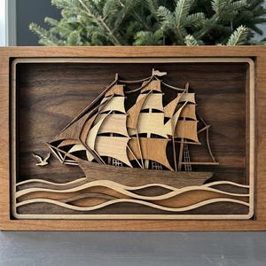 May include: A white ceramic mug with a black handle and the text "But First, Coffee" in a bold, black font. The mug is set against a blurred background, suggesting a cozy setting.