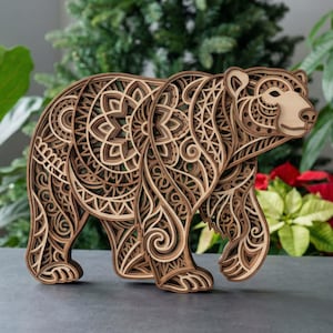 Op de afbeelding: Een houten berensculptuur met ingewikkelde gelaagde ontwerpen. De beer wordt afgebeeld in een wandelhouding, met gedetailleerde patronen in zijn lichaam gesneden. De sculptuur is gemaakt van verschillende bruintinten, waardoor een 3D-effect ontstaat.