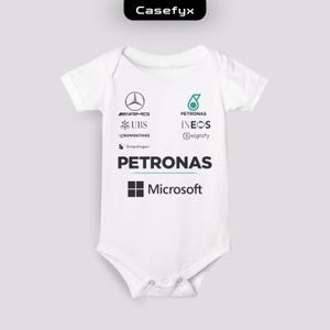 Könnte beinhalten: Ein weißer kurzärmeliger Babybody mit verschiedenen aufgedruckten Logos, darunter Mercedes-AMG, Petronas, UBS, Ineos, CrowdStrike, Signify, Snapdragon und Microsoft. Das Kleidungsstück hat einen Rundhalsausschnitt und Druckknöpfe im Schrittbereich.