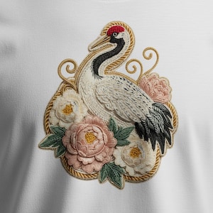 May include: Embroidered design of a crane with a red crown, black and white markings, and a long neck. The crane is surrounded by pink and white peonies and green leaves, within a gold rope border. The design is on a white background.