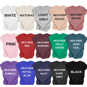 May include: A collection of t-shirts in various colors, including white, pink, red, and black. Each shirt displays its color name in bold, black text. The shirts are arranged in rows, showcasing a range of hues and shades.