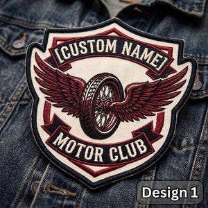 May include: A shield-shaped embroidered patch featuring a central motorcycle wheel with dark red wings. The patch has a cream background with dark red and black borders. Text reads [CUSTOM NAME] at the top and MOTOR CLUB at the bottom in black.