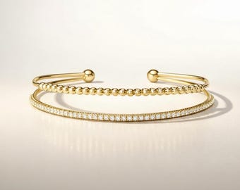 Brazalete minimalista de acero inoxidable con cuentas doradas y circonitas, ajustable y abierto.