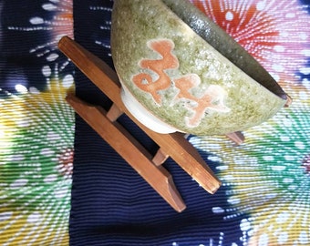 Vintage Japanese hand-made stoneware glazed tea bowl, chawan .Calligraphy, green textured glaze with pink slip.  White stoneware body.