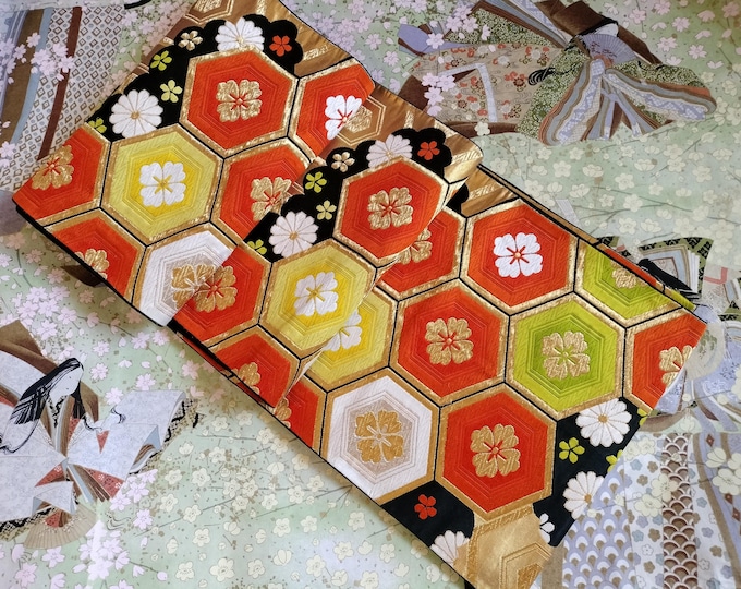 Black and gold vintage Japanese Fukuro formal obi for kimono. Woven pattern of geometric floral design in vibrant orange, green metallic.