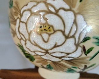 Vintage Japanese hand-made Kyo-ware glazed tea bowl, chawan .  Peony flower on glaze. White stoneware body with cream crackle glaze.