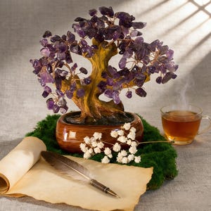May include: A decorative amethyst gemstone tree in a brown ceramic pot, with a cup of tea, a rolled parchment, and a feather quill. The tree has purple gemstone leaves and copper wire branches. The scene is set on a bed of green moss.