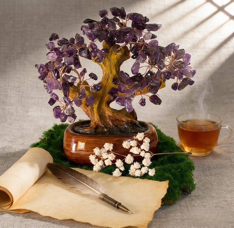 May include: A decorative amethyst gemstone tree in a brown ceramic pot, with a cup of tea, a rolled parchment, and a feather quill. The tree has purple gemstone leaves and copper wire branches. The scene is set on a bed of green moss.