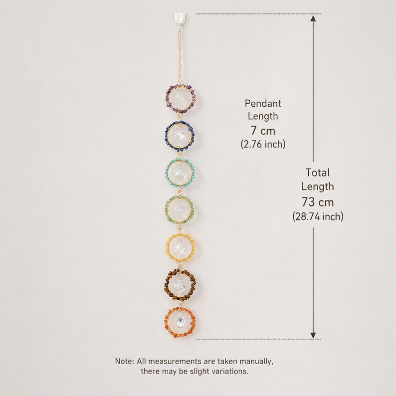 May include: A vertical hanging ornament featuring seven circular rings, each containing a clear crystal, arranged in a rainbow color sequence. The pendant length is 2.76 inches and the total length is 28.74 inches. Text indicates manual measurements.