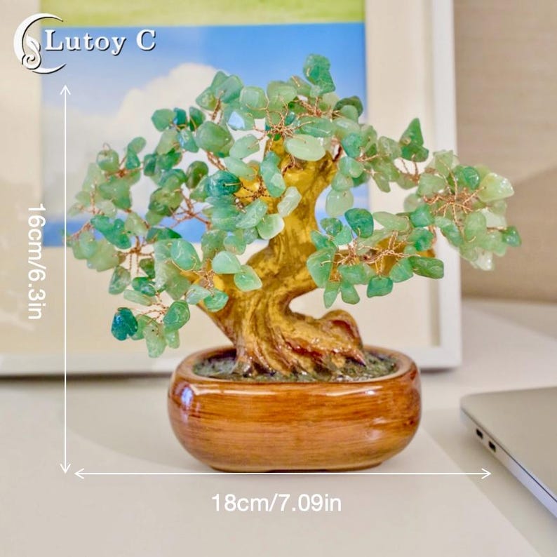 May include: A decorative bonsai tree made of green gemstone leaves and a golden-brown trunk. The tree sits in a brown ceramic pot. The tree is 6.3 inches tall and 7.09 inches wide.