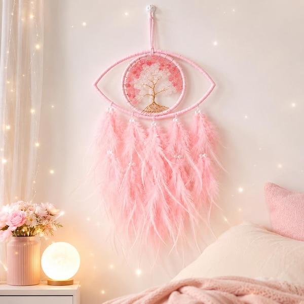 May include: A wall hanging featuring a pink eye-shaped frame containing a wire tree sculpture with pink and white crystal leaves. The frame is adorned with long, soft pink feathers hanging from the bottom, accented with small white beads.