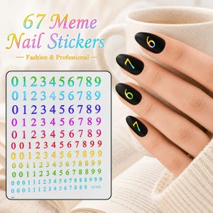 May include: A sheet of nail stickers featuring rows of numbers from 0 to 9 in various gradient colors. The text 67 Meme Nail Stickers Fashion & Professional is visible. Four black fingernails display applied number stickers in iridescent hues.