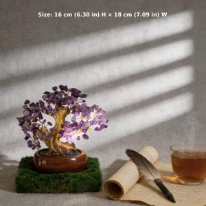 May include: A decorative bonsai tree with purple amethyst leaves, set in a brown pot on a mossy base. The tree is 6.30 inches high and 7.09 inches wide. A scroll, feather pen, and a cup of tea are next to the tree.