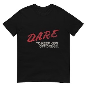 May include: Black t-shirt with the text "D.A.R.E. TO KEEP KIDS OFF DRUGS" in red and white. The text has a distressed, vintage look. The shirt is a short-sleeved crew neck.