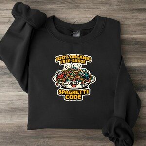 May include: A black crewneck sweatshirt featuring a graphic of a bowl of colourful spaghetti with a smiling face. The text reads 100% ORGANIC FREE-RANGE SPAGHETTI CODE. The design includes a small ladybird and a blue creature nestled in the noodles.