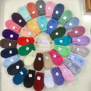 May include: A collection of 38 knitted fingerless gloves in various colours, including red, blue, green, yellow, pink, purple, and brown. The gloves are arranged in a circle, with the numbers 1 through 38 written on each glove.