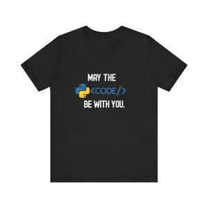 Op de afbeelding: Zwart t-shirt met de tekst "MAY THE <CODE/> BE WITH YOU." Het ontwerp bevat een Python-logo en codesymbolen in blauw en geel. Een casual t-shirt voor programmeurs en tech-liefhebbers.