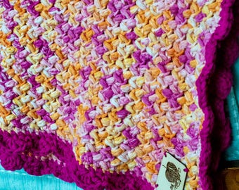 Fuchsia. En handgjord, unik och livfull virkad filt i rosa och orange.