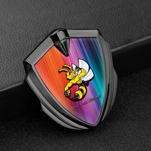 Könnte beinhalten: Schwarzes schildförmiges Emblem mit einem Regenbogenhintergrund. Eine gelbe Cartoon-Biene mit weißem Umhang ist auf dem Emblem zentriert. Der Text "DONT FUCK WITH ME" ist unten aufgedruckt.