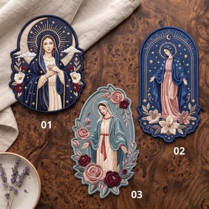 May include: Three embroidered patches featuring religious figures. Patch 01 shows a figure in a dark blue cloak with a crescent moon and stars. Patch 02 depicts a figure in a blue cloak with stars and flowers. Patch 03 shows a figure with roses.