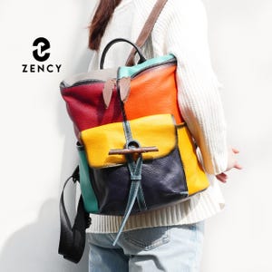 Könnte beinhalten: Ein mehrfarbiger Lederrucksack mit Klappenverschluss. Der Rucksack hat eine Kombination aus roten, orangefarbenen, gelben, türkisfarbenen und marineblauen Einsätzen. Der Markenname "ZENCY" ist oben links aufgedruckt.