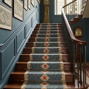 Peut inclure: Un escalier majestueux avec des marches en bois et un tapis bleu orné d'un motif géométrique. Les murs sont peints en bleu foncé et décorés d'œuvres encadrées. Une horloge de grand-père se dresse sur le palier, ajoutant à l'esthétique classique.
