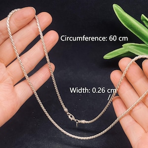 May include: A silver-toned rope chain necklace featuring a twisted metal link design. The necklace has a lobster claw clasp and a small tag. Text on the image indicates a circumference of 60 cm and a width of 0.26 cm for this metal chain.