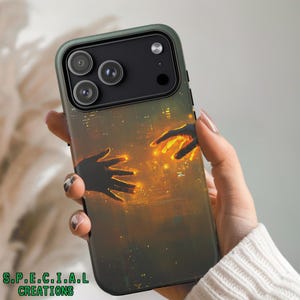 Pode incluir: Uma capa de telefone com uma borda verde escura e um design com duas mãos se estendendo uma para a outra com luz brilhante. O fundo retrata uma paisagem urbana. O texto "S.P.E.C.I.A.L CREATIONS" está na parte inferior.