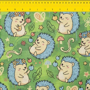 Pode incluir: Um padrão repetido de ouriços sorridentes com espinhos azuis, segurando maçãs e usando coroas de flores, em um fundo verde com folhas, cogumelos e estrelas. O design do tecido é caprichoso e alegre.